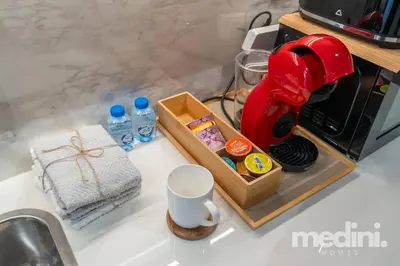 a kitchen counter with a red mixer next to a sink at 12min from Burj Khalifa - Studio - Azizi Riviera in Dubai