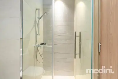a glass shower with a toilet in a bathroom at 12min from Burj Khalifa - Studio - Azizi Riviera in Dubai