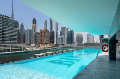 a swimming pool on the roof of a building with a city at Sophisticated Binghatti Canal in Dubai