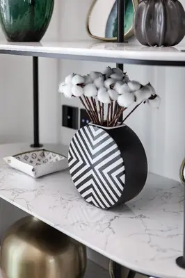a black and white vase with flowers on a shelf at Sophisticated Binghatti Canal in Dubai