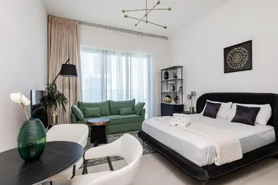 a bedroom with a large bed and a green couch at Sophisticated Binghatti Canal in Dubai