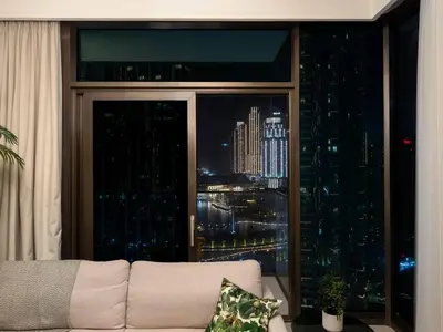 a couch in front of a large window with a city skyline at 2BR-Downtown Apartment- 10 Min Walk to Dubai Mall in Dubai