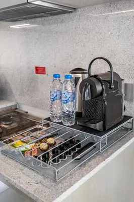a kitchen counter with two bottles of water and food at Cosmic Sky Suite High floor 1BR- Dubai Mall Access by Maxx Value Homes in Dubai
