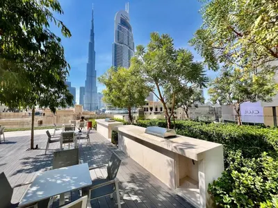 a patio with tables and chairs and a view of the city at Cosmic Sky Suite High floor 1BR- Dubai Mall Access by Maxx Value Homes in Dubai