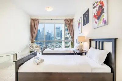 a bedroom with two beds and a large window at Extra Spacious Home with Stunning Marina Views in Dubai