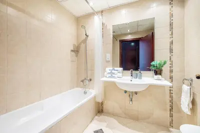 a bathroom with a tub and a sink and a bath tub at Extra Spacious Home with Stunning Marina Views in Dubai