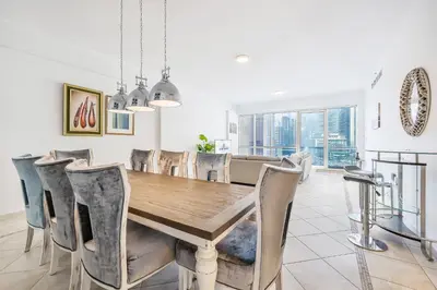 a dining room with a wooden table and chairs at Extra Spacious Home with Stunning Marina Views in Dubai