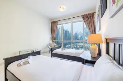 a hotel room with two beds and a window at Extra Spacious Home with Stunning Marina Views in Dubai
