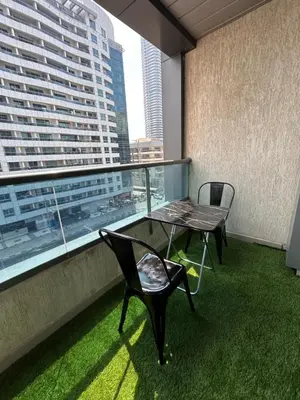 a table and chairs on a balcony with a view of a city at Luxury Studio Apartment In Dubai Marina in Dubai