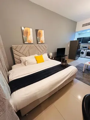a bedroom with a large white bed with yellow pillows at Luxury Studio Apartment In Dubai Marina in Dubai