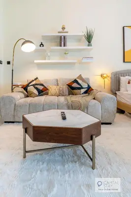 a living room with a couch and a coffee table at Capital Stay - Cozy Studio in Liwan Dubai in Dubai