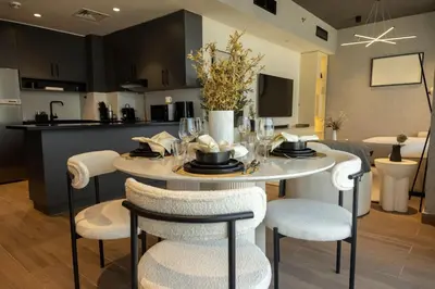 a dining room and kitchen with a table and chairs at WelHome - LOCI Residences in Dubai