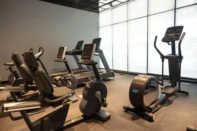 a gym with rows of cardio machines in a room at WelHome - LOCI Residences in Dubai