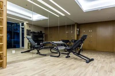 a gym with a row of chairs and mirrors at Waves - Luxury Meets Comfort, Modern 1BR in JVCs Luma22 in Dubai