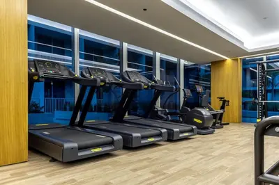 a gym with a row of treadmills at Waves - Luxury Meets Comfort, Modern 1BR in JVCs Luma22 in Dubai