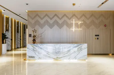 a lobby with a large marble table in front of a wall at Old Form in Dubai