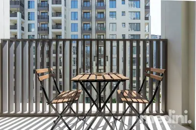 two chairs and a table on a balcony at 1-Bedroom - in Emaar Creek Harboor in Dubai