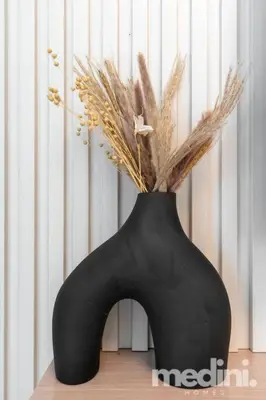 a black vase with grasses in it on a table at 1-Bedroom - in Emaar Creek Harboor in Dubai