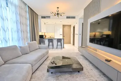 a living room with a couch and a tv at Chic Retreat 1BR in District One Meydan in Dubai