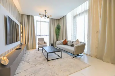 a living room with a couch and a tv at Family-friendly 1 Bedroom in District One Meydan in Dubai