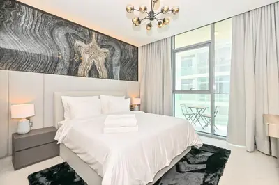 a bedroom with a white bed and a large window at Gorgeous 1 Bedroom in District One Meydan in Dubai