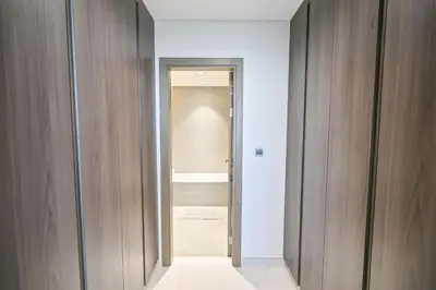 a hallway with wooden walls and a door to a bathroom at Modern 1BR in District One Meydan in Dubai