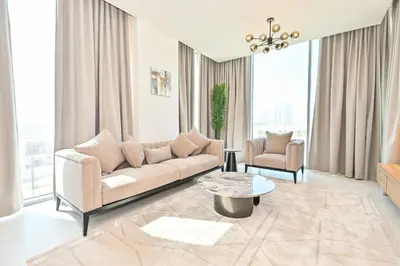 a living room with a couch and a table at Modern 1BR in District One Meydan in Dubai