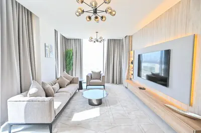 a living room with a couch and a tv at Modern 1BR in District One Meydan in Dubai