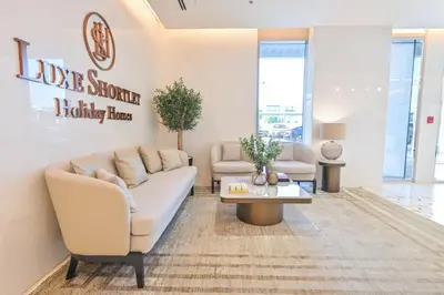a living room with a couch and a table at 1BR w Exclusive Lagoon Access in District One Meydan in Dubai