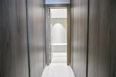 a hallway with wooden walls and a door to a bathroom at 1BR w Exclusive Lagoon Access in District One Meydan in Dubai