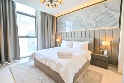 a bedroom with a white bed with a map on the wall at 1BR w Exclusive Lagoon Access in District One Meydan in Dubai
