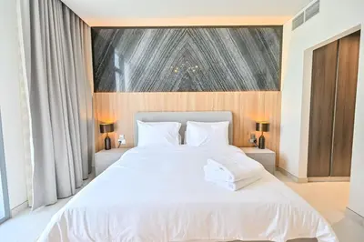 a bedroom with a large white bed with white pillows at Luxury and Spacious 1 Bedroom in District One Meydan in Dubai