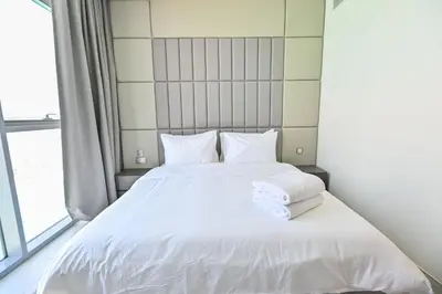 a bedroom with a white bed with towels on it at Magnificent 2BR in District One Meydan in Dubai