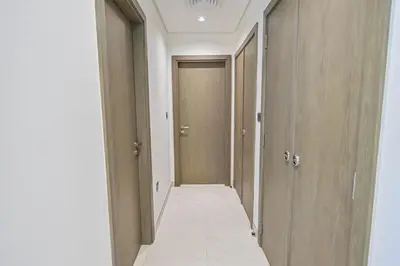 an empty hallway with doors and a tile floor at Magnificent 2BR in District One Meydan in Dubai