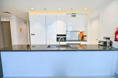 a kitchen with white cabinets and a sink at Magnificent 2BR in District One Meydan in Dubai