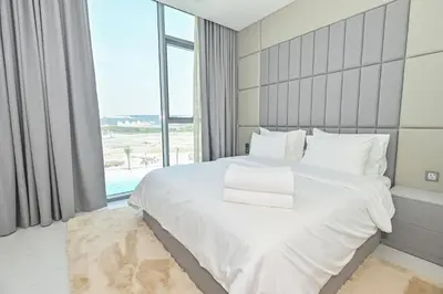 a bedroom with a large white bed and a large window at Premium 2 Bedroom in District One Meydan in Dubai