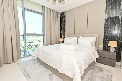 a bedroom with a white bed and a large window at 1BR Haven with Lagoon Serenity in District One Meydan in Dubai