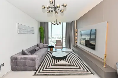 a living room with a couch and a table at Spacious 1BR with Burj Khalifa View in District One Meydan in Dubai