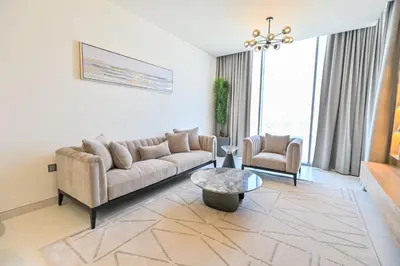 a living room with a couch and a table at Unique 1BR in District One Meydan in Dubai