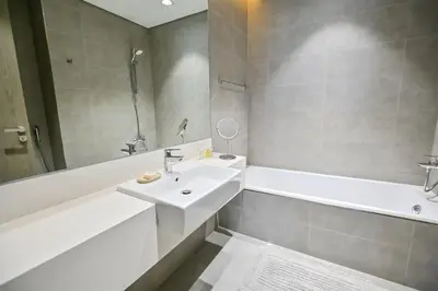 a bathroom with a sink and a tub and a mirror at Unique 1BR in District One Meydan in Dubai