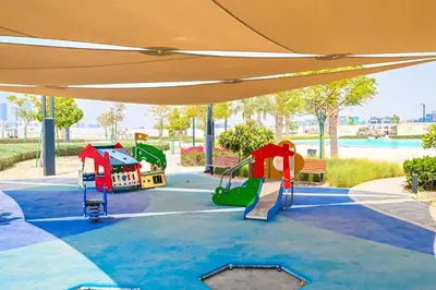 a playground in a park with an orange canopy at 1BR by Dubai Crystal Lagoon in District One Meydan in Dubai