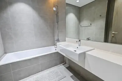 a bathroom with a white sink and a bath tub at Unique 1 Bedroom in District One Meydan in Dubai
