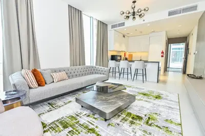 a living room with a couch and a table at Unique 1 Bedroom in District One Meydan in Dubai