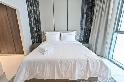 a bedroom with a white bed with white sheets at Unique 1 Bedroom in District One Meydan in Dubai