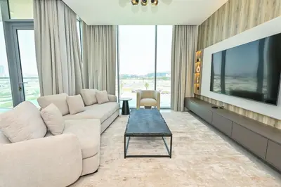 a living room with a couch and a tv at Unique 2 Bedroom in District One Meydan in Dubai
