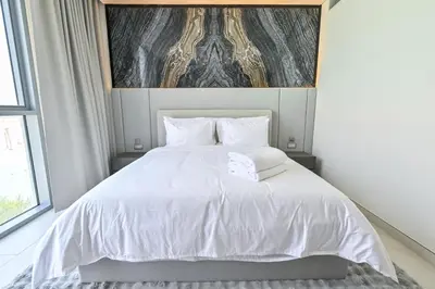 a white bed with white sheets and pillows at Unique 2 Bedroom in District One Meydan in Dubai