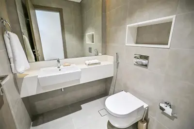 a bathroom with a white toilet and a sink at 1BR Retreat by the Crystal Lagoon in District One Meydan in Dubai