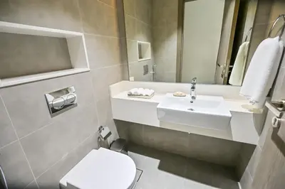 a bathroom with a sink and a toilet and a mirror at 1BR with Lagoon Views in District One Meydan in Dubai