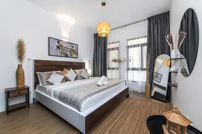 a bedroom with a large bed and a large window at Bright 1Bdr at Fortunato in Dubai