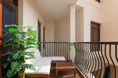 a balcony with a bench and a plant at Bright 1Bdr at Fortunato in Dubai